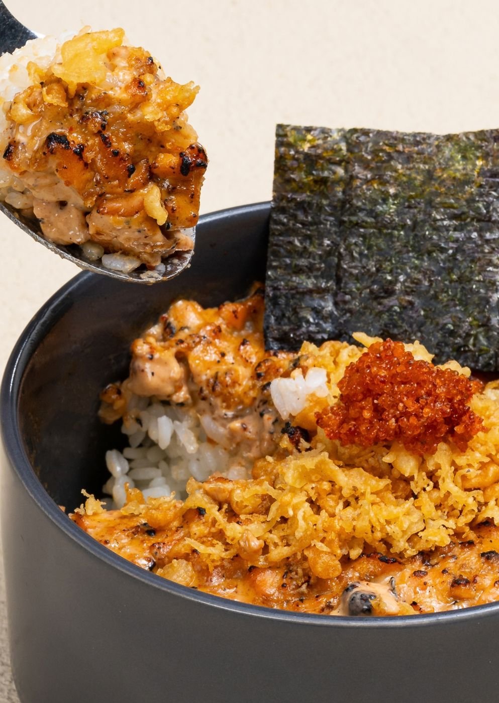 Spoonful of torched salmon rice over a donburi bowl